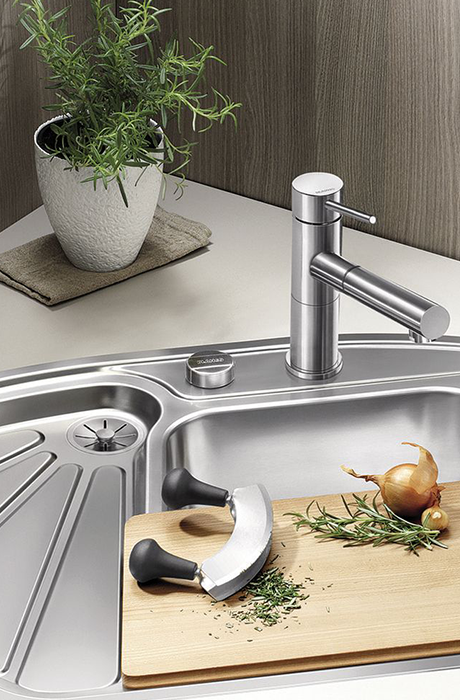 in the kitchen there is a stainless steel sink with 3 different compartments